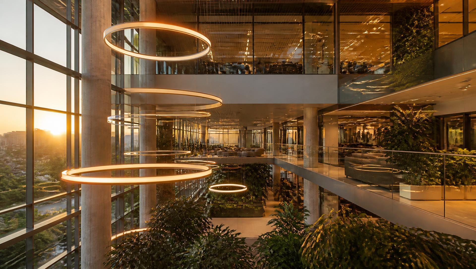 Kantooratrium met grote ronde LED-ringarmaturen en glazen balustrades